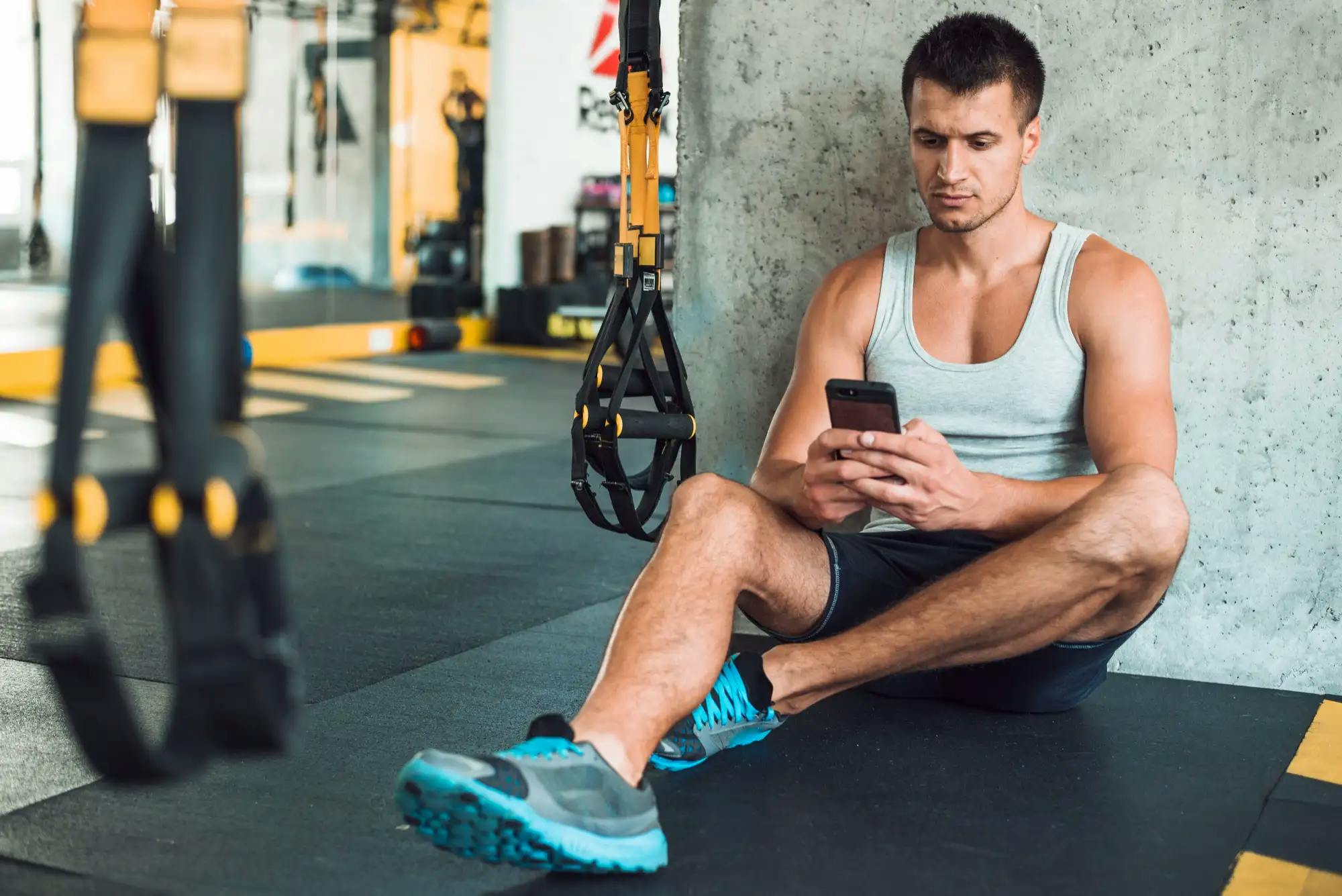 man-using-phone-in-gym